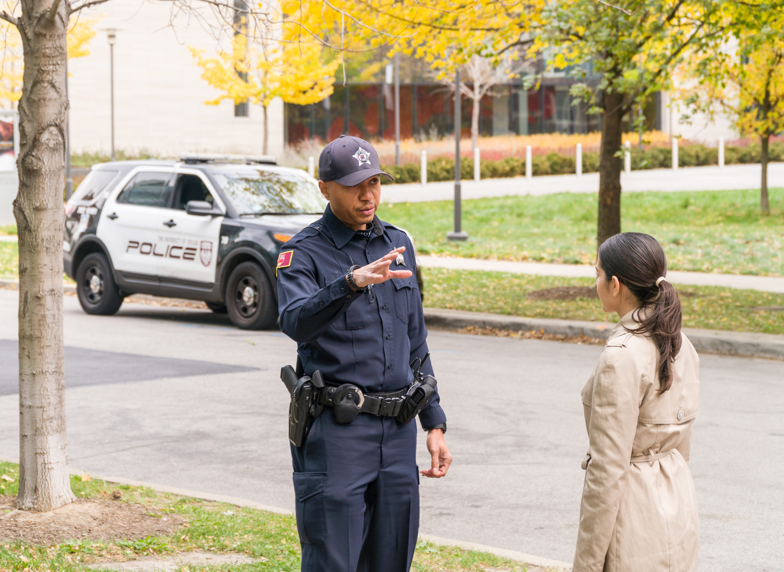 police officer talks to a female on the sidewalk of UChicago campus on an autumn day