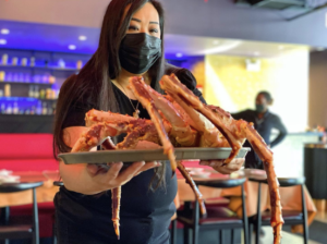 Carol Cheung hold crab inside Jade Court Hyde Park Chicago Restaurant Woman-Owned
