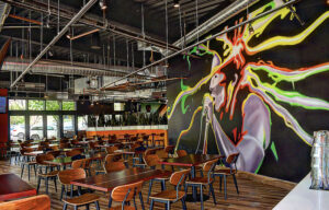 Interior seating of Ja Grill cafe with a large reggae mural on the wall. 